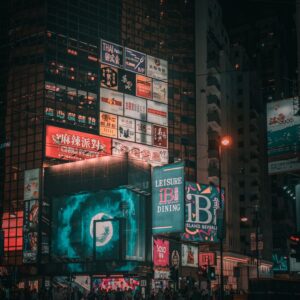 Low angle of digital screens and billboards with colorful advertisement on modern skyscrapers in city at night